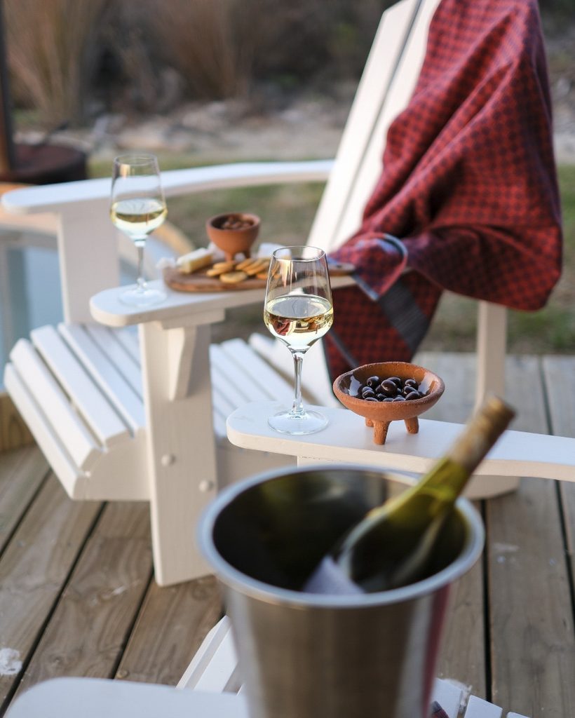 Outdoor hot tub area with wine, blankets and seating in the garden