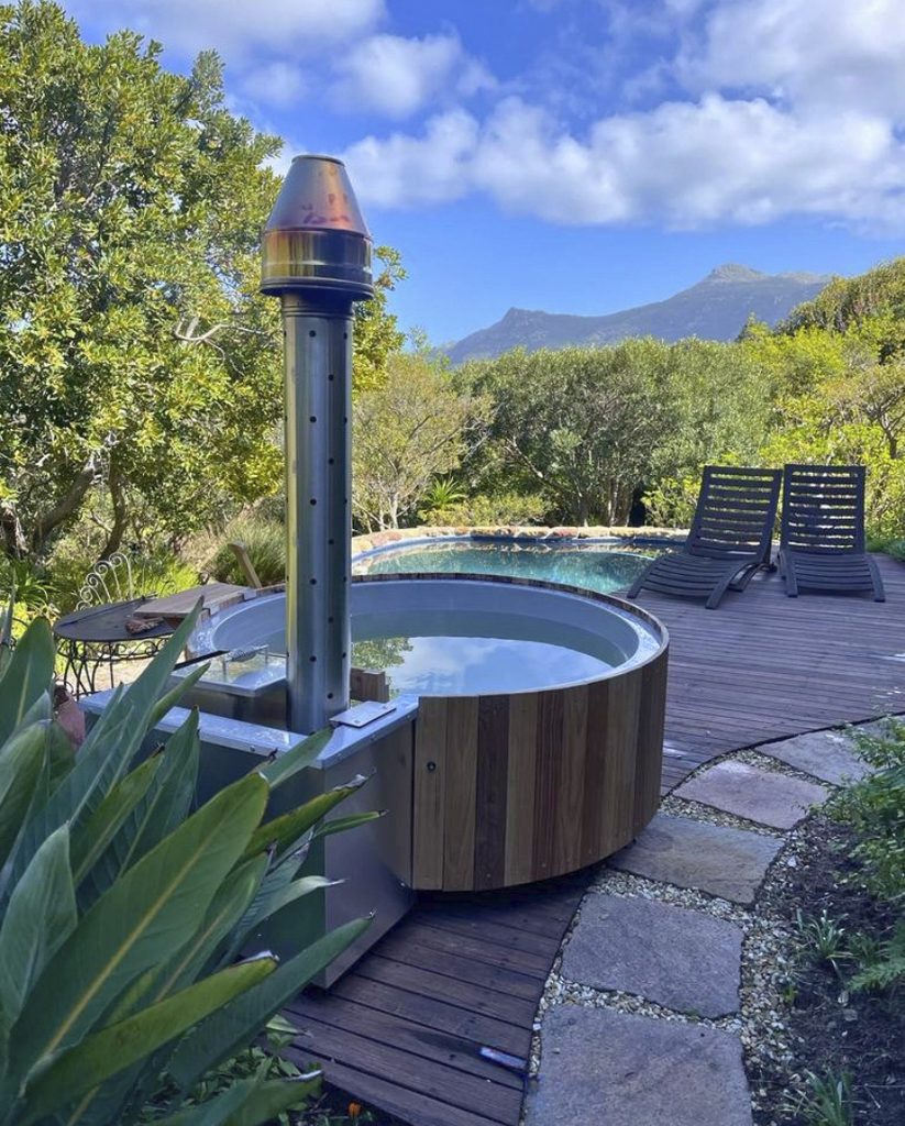 Hot tub integrated into a landscaped garden with pool and mountain views
